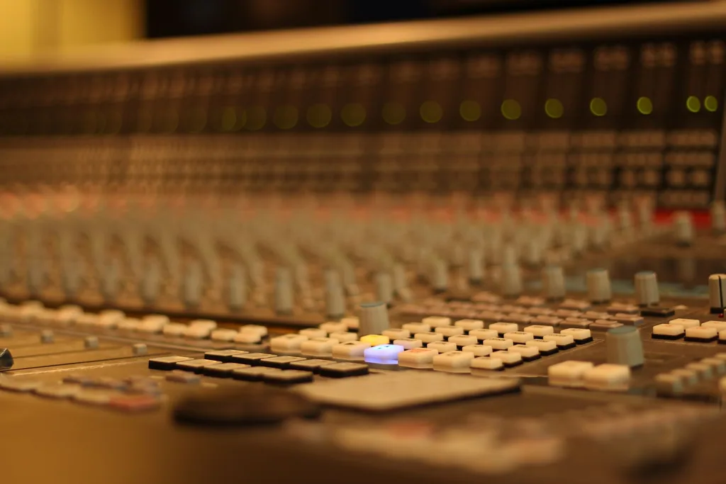 Professional audio mixing console with illuminated faders and buttons at Limusic residential recording studio in Limoux, France