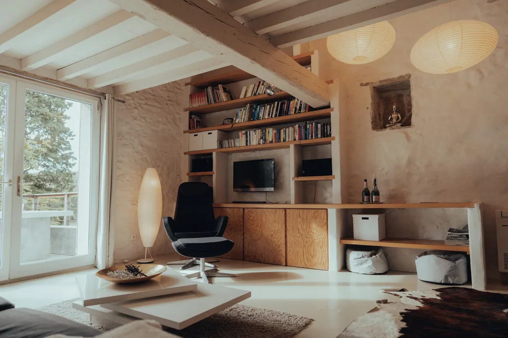 Modern apartment interior with wooden shelving, black chair, and glass balcony door overlooking southern France estate at Limusic Residential Recording Studio