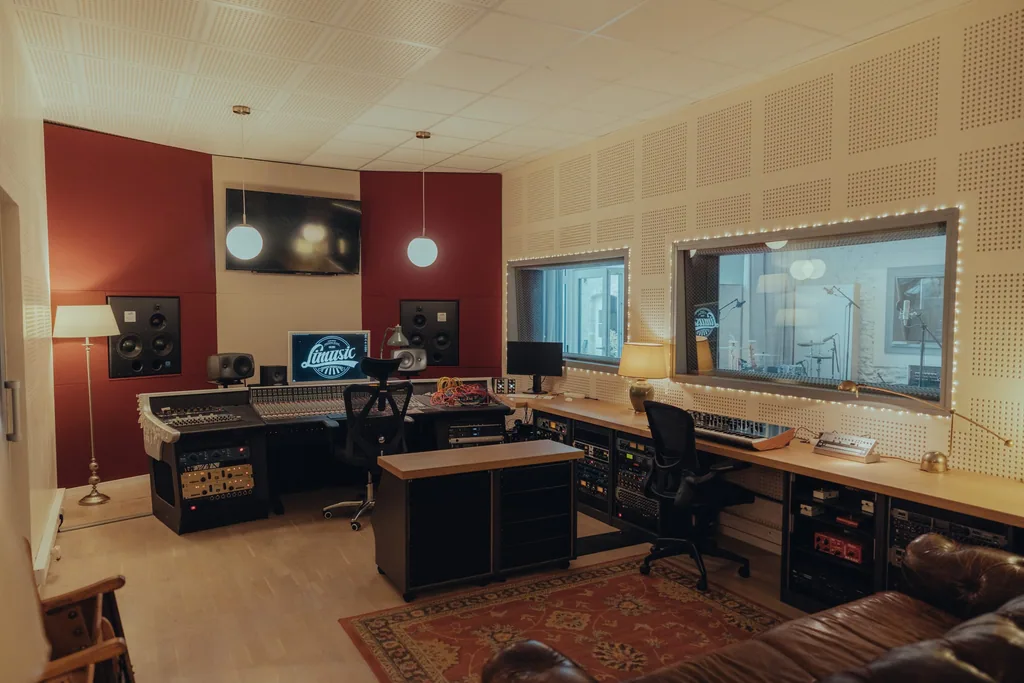 Professional recording studio control room with mixing console, studio monitors, and live room visibility at Limusic residential recording studio in Limoux, southern France