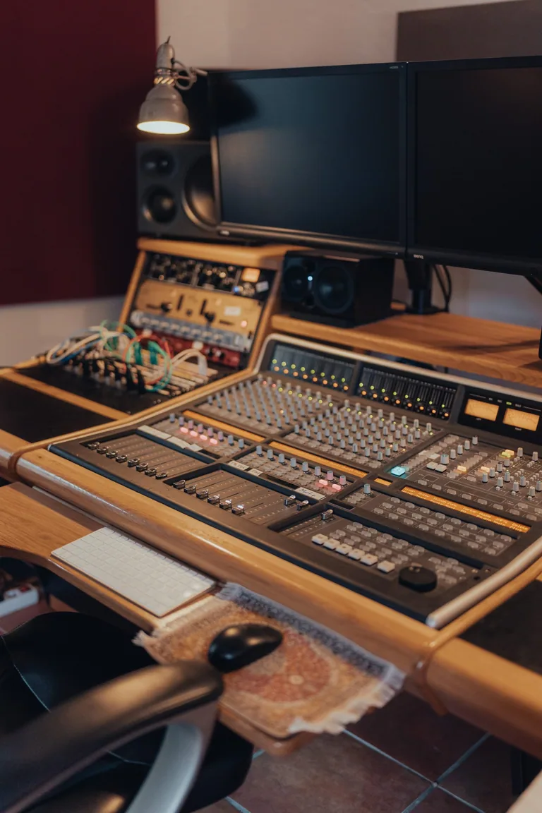 Recording studio control room with professional mixing console, dual monitors, and outboard gear at Limusic residential recording studio in southern France