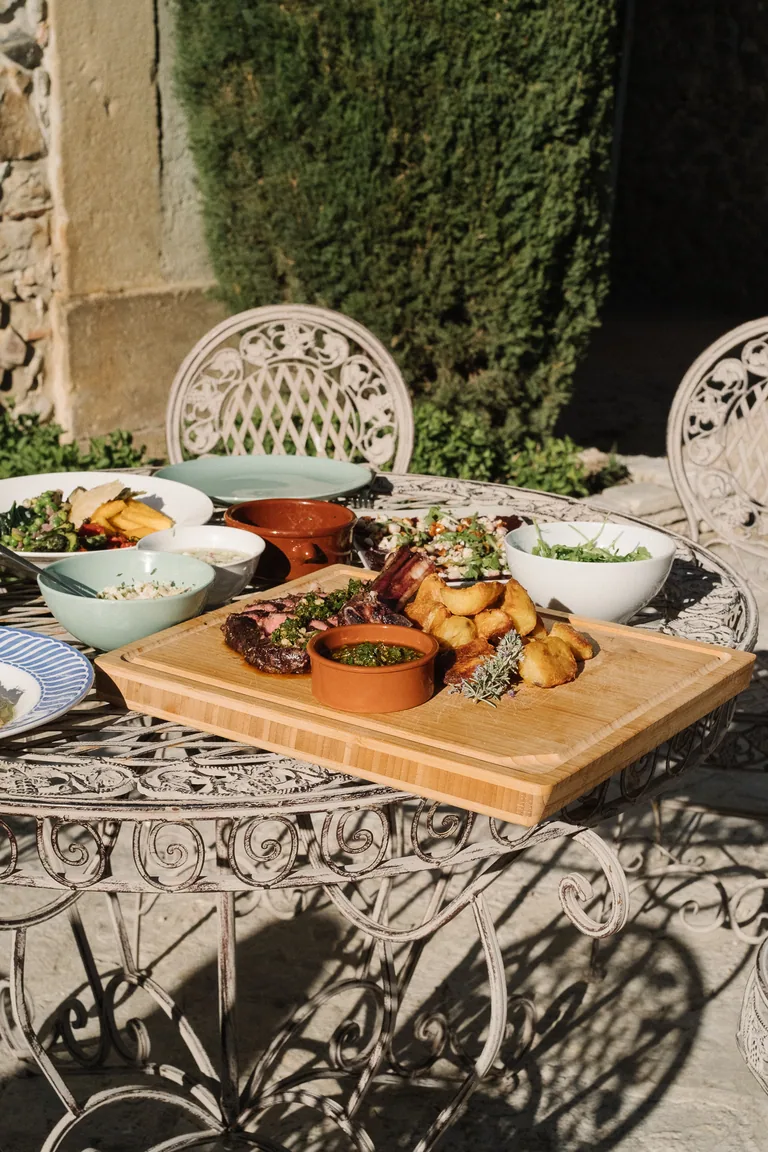 Outdoor meal served at Limusic residential recording studio in Limoux, featuring grilled meat, roasted potatoes and regional dishes on ornate garden table