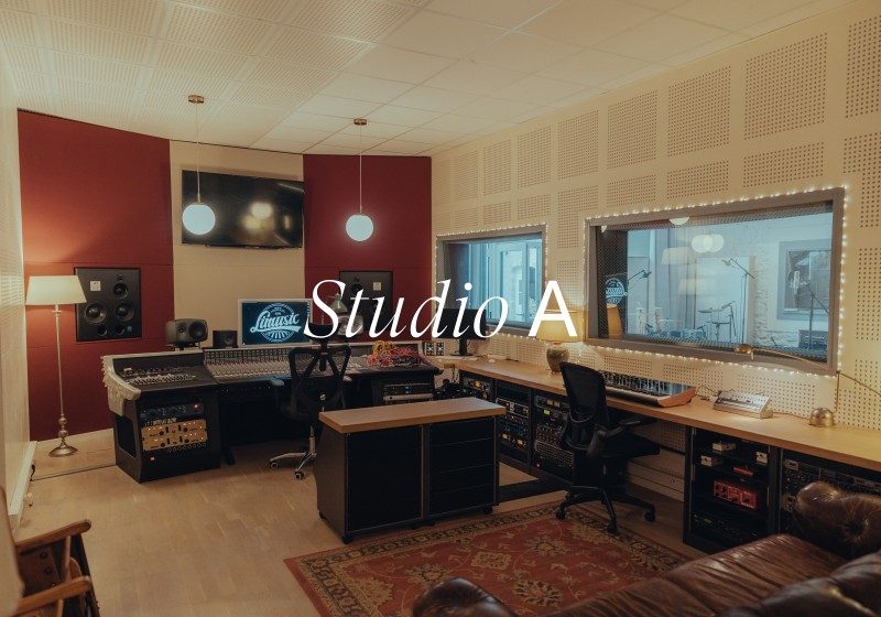 Studio A recording room with mixing console, acoustic panels, and control room windows at Limusic residential studio