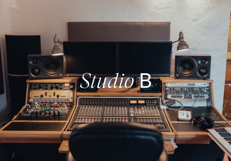 Professional recording studio control room with mixing console, dual monitors, studio monitors, and vintage synthesizers at Limusic residential recording studio in southern France