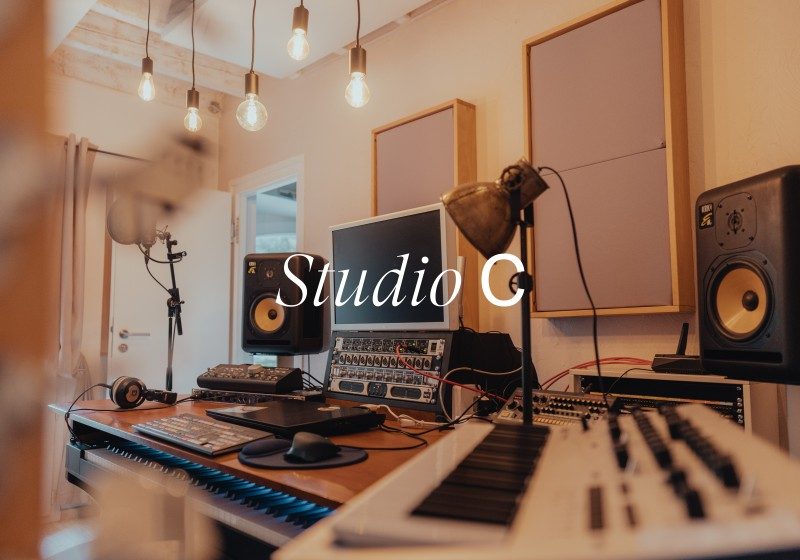 Professional recording studio workspace with mixing console, studio monitors, microphone, keyboard, and acoustic treatment panels at Limusic residential recording studio
